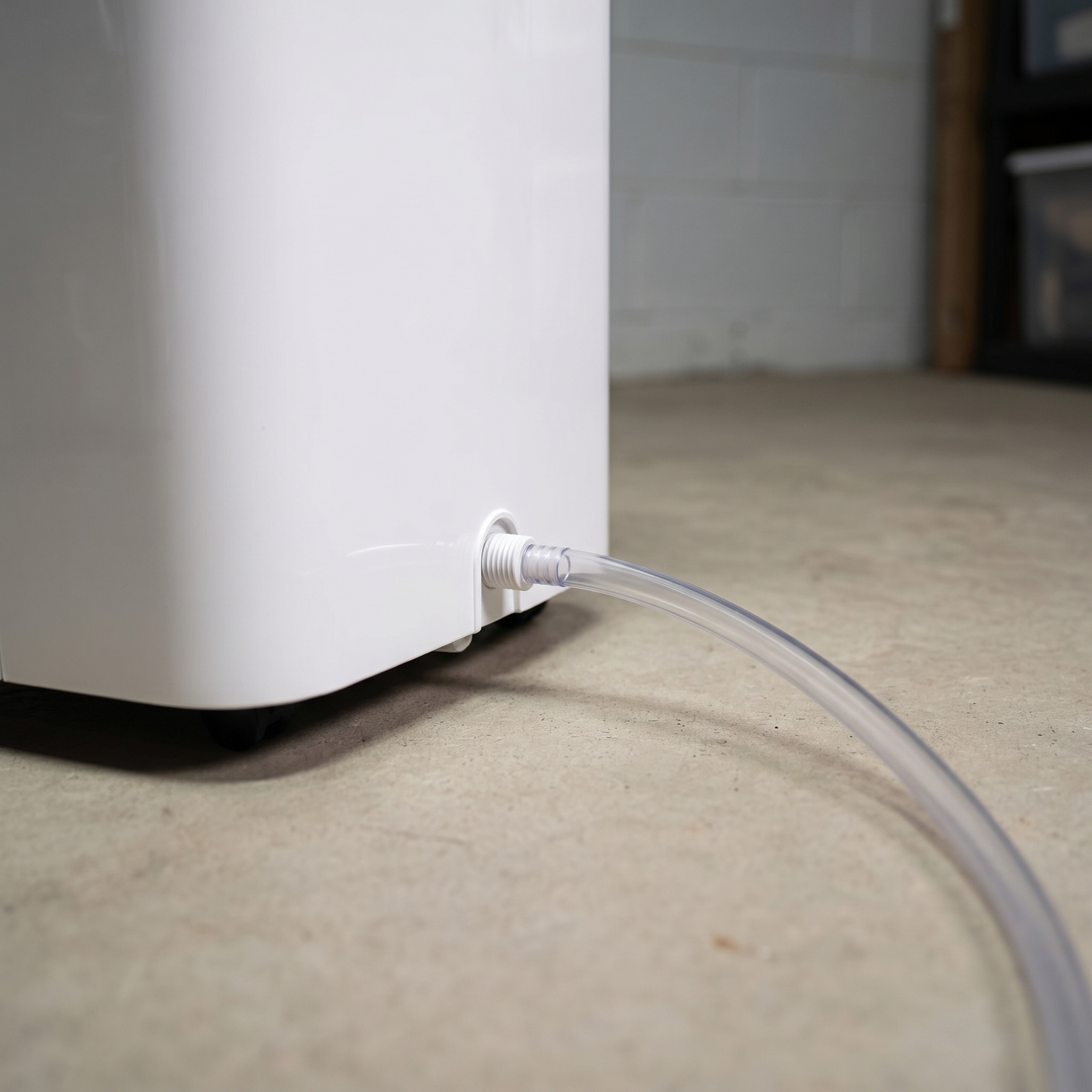Close-up of the DryHaven gravity drain hose connection at the base of the unit